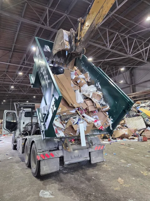 Conteneur Megabac basculé au centre de disposition de Longueuil : une pelle mécanique décolle les matériaux gelés aux parois