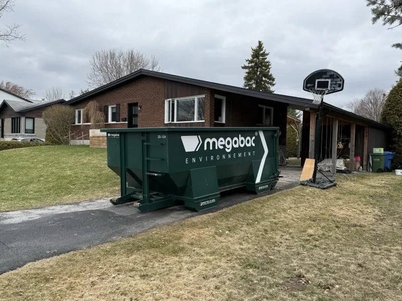 Conteneur de 20 verges cube appuyé sur ses madriers PROTEC-O-SOL dans une entrée d'asphalte récente