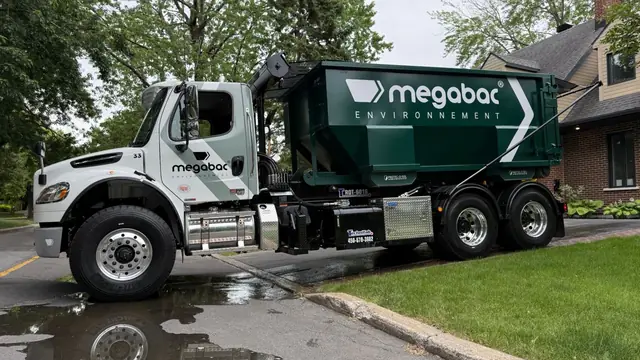 Camion blanc Megabac livrant un conteneur